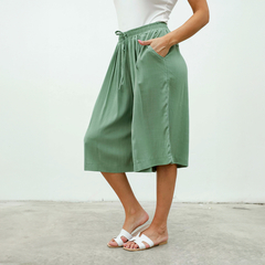Modelo usando pantalones Capri Dayak de color verde, con un diseño holgado y cintura elástica.