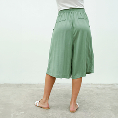 Vista trasera de un pantalón Capri color verde, con bolsillos y cintura elástica.