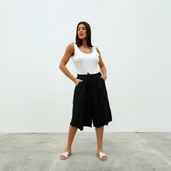Pantalones cortos negros Capri Dayak con una modelo que lleva una camiseta blanca.