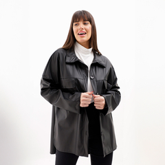 Chaqueta Zenda de color negro, con un diseño elegante y moderno, combinada con un suéter blanco y pantalones oscuros.