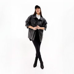 Modelo luciendo una chaqueta Zenda de color negro, con pantalones ajustados y botas, en un fondo blanco.