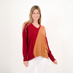 Modelo luciendo un suéter de corte amplio en rojo y naranja, con un escote en V.