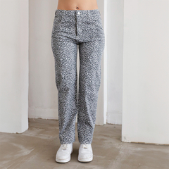 Pantalones de estampado de leopardo en tonos grises, con una modelo de pie usando zapatillas blancas.