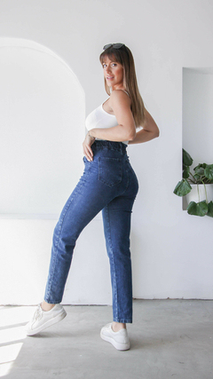 Pantalones jeans baggy de color azul, con modelo posando de perfil en un ambiente luminoso.