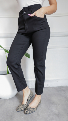 Pantalones baggy negros con cintura alta y bolsillos, combinados con zapatos de animal print.