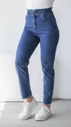 Jean baggy de color azul, con cintura alta y ajuste fruncido, combinado con zapatillas blancas.