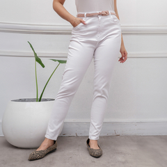 Jean blanco ajustado con cinturón, modelo femenino, posando en un entorno minimalista.