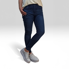 Jeans Dixy de mujer en color azul oscuro, con una camiseta clara y zapatillas blancas.