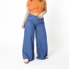 Jeans Gotic de corte ancho, combinados con una blusa naranja, sobre fondo blanco.