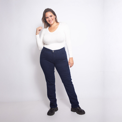 Mujer sonriente vistiendo jeans azul oscuro estilo Memphis con camiseta blanca y botas negras