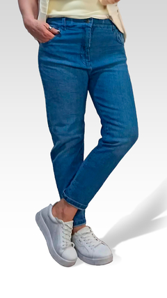 Jean MOM de corte moderno, en color azul, combinado con zapatillas blancas.