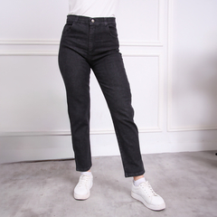 Jean MOM negro de tiro alto, con un diseño moderno y ajustado, combinado con zapatillas blancas.