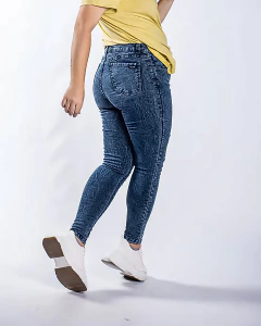 Jeans nevado de mujer, de corte ajustado, con un diseño de textura en azul, combinados con una camiseta amarilla y zapatillas blancas.