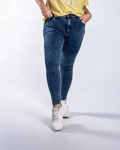 Jeans nevados de color azul oscuro, con un diseño arrugado, combinados con una camiseta amarilla y zapatillas blancas.