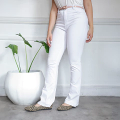 Pantalones jeans semi oxford blancos, con una modelo posando frente a una planta.