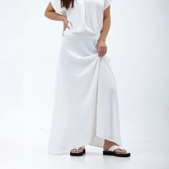 Modelo luciendo una maxi falda blanca Nalami, de largo hasta los pies, con un diseño sencillo y elegante.