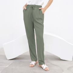 Pantalón Chenoa de color verde, con cintura elástica y bolsillos, combinado con una camiseta blanca y sandalias.