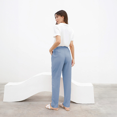 Pantalón Chenoa de color azul claro visto desde atrás, combinado con una blusa blanca y sandalias.