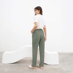 Pantalón Chenoa en color verde, visto desde atrás, combinado con una camiseta blanca y sandalias.