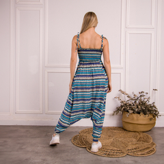 Mono de mujer con tirantes, estampado en tonos azules y verdes, visto desde atrás.