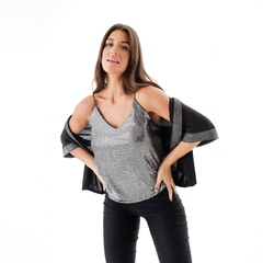 Modelo luciendo una musculosa Piper con detalles brillantes, combinada con una chaqueta negra, en un fondo blanco.