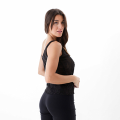 Musculosa negra de encaje con tirantes, modelo de perfil, mostrando detalles del diseño.