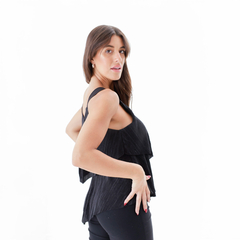 Musculosa negra con detalles en capas, modelo posando de perfil.