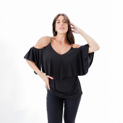 Modelo luciendo una musculosa negra de diseño moderno con mangas amplias y escote en V.