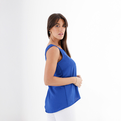 Musculosa Ronnie de color azul, vista lateral de una mujer que la lleva puesta, con fondo blanco.