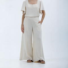 Pantalones palazzo Kalindi de color beige, con una blusa de mangas amplias, diseñados para un look elegante y cómodo.