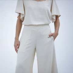Pantalones palazzo Kalindi en color beige, con un diseño fluido y cómodas bolsillos laterales.
