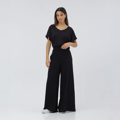 Modelo vistiendo un palazzo negro llamado Lindira, con una blusa de manga corta y pantalones anchos.
