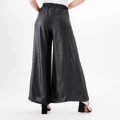 Pantalones palazzo negros brillantes, vistos desde atrás, con un diseño amplio y cómodo.