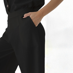 Pantalón palazzo negro con detalle de bolsillo y mano en el costado.