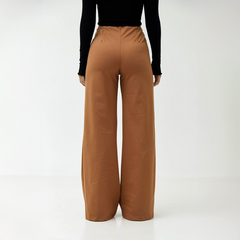 Pantalones palazzo de color marrón vistos desde atrás, con cintura elástica.