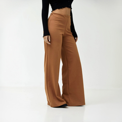 Pantalones palazzo de color marrón de la marca Punto Roma, con una blusa negra en un fondo blanco.