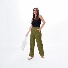 Pantalones palazzo Sabrina de color verde oliva, con una modelo que lleva una blusa negra y sandalias blancas, sosteniendo una bolsa de red.