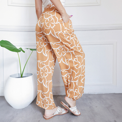 Pantalones Palazzo Vivi de color naranja con estampado floral, vista trasera.