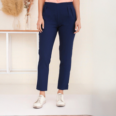 Pantalón Milen en color azul marino, con un diseño moderno y cortes elegantes, usado por una modelo que lleva una blusa rosa y zapatillas blancas.