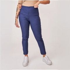 Pantalón Belice de color azul marino, con diseño ajustado y cintura alta, modelo con tatuajes en el brazo, usando zapatillas blancas.