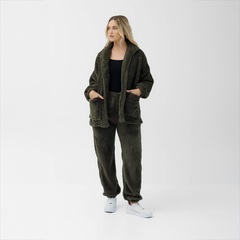 Modelo luciendo un pantalón Calgaro de color verde oliva, con un abrigo a juego y zapatillas blancas, en un fondo blanco.