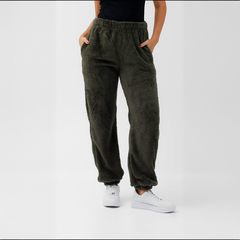Pantalón de felpa color verde oliva con bolsillos y cintura elástica, modelo femenino.