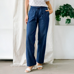 Pantalón Lorena de tiro alto, color azul, con cintura elástica y bolsillos laterales, lucido por una modelo en un ambiente luminoso.