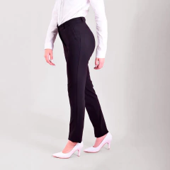 Pantalón Luisa negro, ajustado, combinado con una blusa blanca y zapatos de tacón rosa.