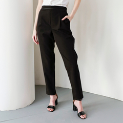 Pantalón negro Mara, con cintura alta y corte moderno, combinado con blusa blanca y sandalias negras de tacón.