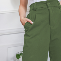 Pantalón sastrero verde con bolsillos y corte elegante, usado por una mujer.