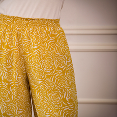 Pantalones Capri Bonnie de color amarillo con estampado de flores blancas.