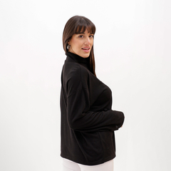 Polera lanilla negra con cuello alto, vista lateral de una mujer sonriendo.