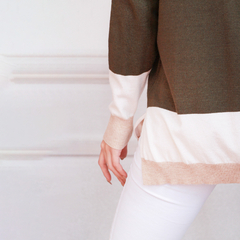 Polera Ligia en tonos verde y beige, vista desde atrás, con una persona usando pantalones blancos.