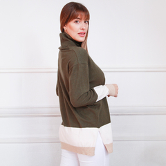 Modelo luciendo una polera de color verde oliva con detalles en blanco y beige.